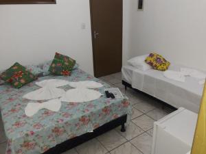 two beds sitting next to each other in a room at Pousada Pelourinho in Mucuri