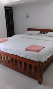 a bed with white sheets and red towels on it at Maria Guest House in Palolem