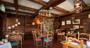 a dining room with wooden walls and tables and chairs at Hôtel Art le Vin - Rhône in Salgesch