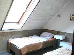 a attic room with two beds and a skylight at Dunakanyar Apartment in Tahitótfalu