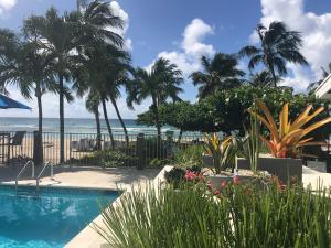 a swimming pool with the beach in the background at Coconut Court Beach Hotel in Bridgetown