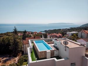 a villa with a swimming pool on top of a building at Apartment Lara with rooftop swimming pool in Ičići