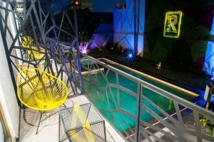 a balcony with a yellow chair and a swimming pool at Ramë Hotel Boutique in Guadalajara