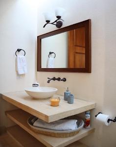 a bathroom sink with a mirror and a towel rack at Hotel & Hostal Boutique Casa Garza in Mérida