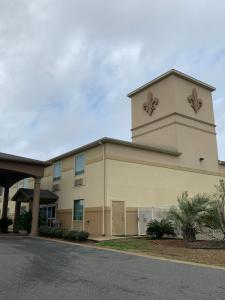 a large tan building with a clock tower at Rodeway Inn & Suites in Winnfield