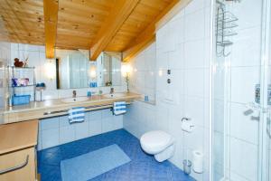 a bathroom with a toilet and two sinks and a shower at Café Chiemgau und Gästehaus in Ruhpolding +47 photos