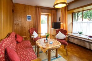 a living room with a couch and chairs and a table at Café Chiemgau und Gästehaus in Ruhpolding