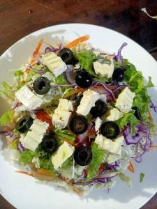 a salad with cheese and olives on a white plate at Sweet Time Bungalows in Koh Rong Sanloem