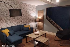 - un salon avec un canapé bleu et une table dans l'établissement Gîte La Gabare entre Loire et Chambord, à Saint-Dyé-sur-Loire