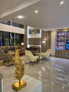 a lobby with chairs and a palm tree in a room at Le Levels Residency in Dammam