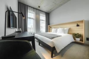 een hotelkamer met een bed en een bureau bij OTTO Hotel & Sun in Pāvilosta