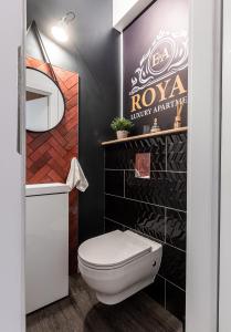 een badkamer met een wit toilet en een zwarte muur bij E&A Royal Luxury Apartments, Bydgoszcz - SKYLINE in Bydgoszcz