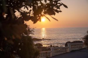 un tramonto sull'oceano con una recinzione bianca di Apartment by the Sea a Porto