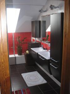 ein Badezimmer mit einem weißen Waschbecken und roten Wänden in der Unterkunft Cichy Zakątek in Krzynowłoga Mała