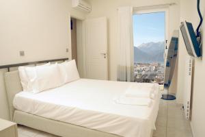 a white bed in a room with a window at #Leonidas# in Sparti