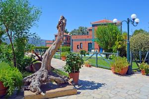una estatua de tronco de árbol en un jardín con plantas en Kalloni Beach Villas, en Skala Kallonis