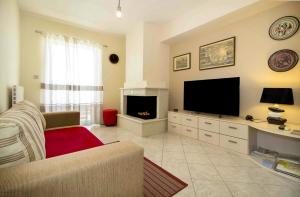 - un salon avec un canapé et une télévision dans l'établissement Laconian Collection Leonidas, à Sparte