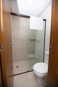 a bathroom with a toilet and a glass shower at ALTA VISTA THERMAS RESORT in Caldas Novas