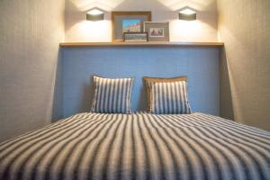 un letto con testiera blu e 2 cuscini di Apartment by the Sea a Porto