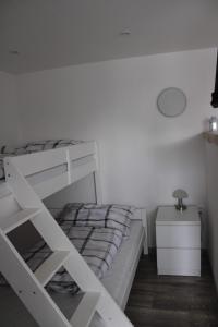 a bedroom with a white bunk bed and a night stand at Ubytovanie Ľaľa in Spišské Tomášovce