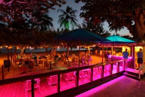a group of people sitting at tables on the beach at night at Coconut Court Beach Hotel in Bridgetown +37 photos