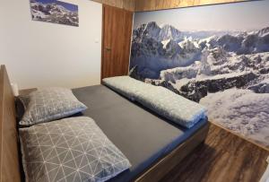 a bedroom with two beds and a painting on the wall at Apartmán Hrebienok Rezort A307 in Starý Smokovec +6 photos