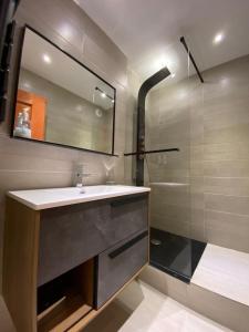 a bathroom with a sink and a mirror and a shower at Superbe appt 2 chambres Arc 1950 in Arc 1950