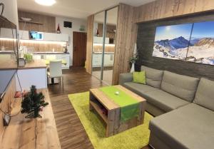 a living room with a couch and a table at Apartmán Hrebienok Rezort A307 in Starý Smokovec