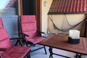 two chairs and a table with a candle on a porch at Nordsee Ferienwohnung für 2 Personen in Wangerland +13 photos