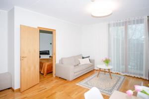 een witte woonkamer met een bank en een tafel bij Küüni 5b Guest Apartment in Tartu