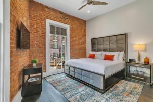 ein Schlafzimmer mit einem Bett und einer Ziegelwand in der Unterkunft The Bacchus in New Orleans