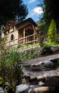 uma cabana de madeira com uma cerca e uma parede de pedra em MOLINO DEL PUENTE em Cuenca