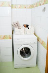 a washing machine with baskets on top in a laundry room at Küüni 5b Guest Apartment in Tartu