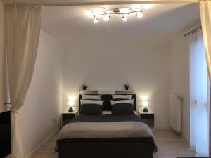 - une chambre avec un grand lit et deux lampes dans l'établissement HOUSE COSY ONE, à Gonesse