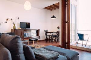 a living room with a couch and a table with chairs at Ponta Branca Beach House in Odeceixe