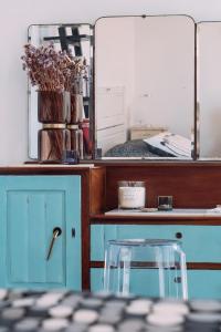 a desk with a blue cabinet and a mirror at Ponta Branca Beach House in Odeceixe
