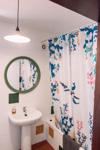 a bathroom with a sink and a shower curtain at Ponta Branca Beach House in Odeceixe