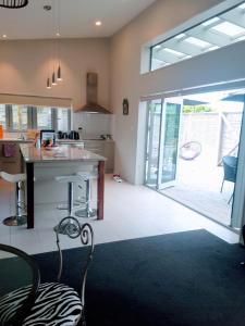 a kitchen with a large glass door leading to a patio at Mangawhai Modern in Mangawhai