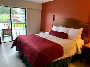een slaapkamer met een bed en een groot raam bij Windsor Motel in Hope