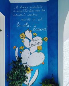 un cartel en una pared con un cactus en Belvedere, en Castro di Lecce