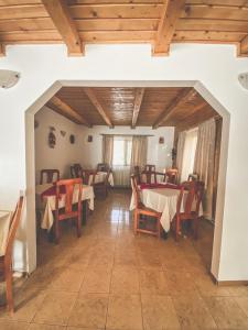 a dining room with tables and chairs and wooden ceilings at Pensiunea Ionela in Zemeş