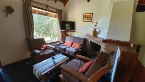 sala de estar con sofás y chimenea en Cabañas & Aparts Lancuyen, Villa de Montaña en Villa La Angostura