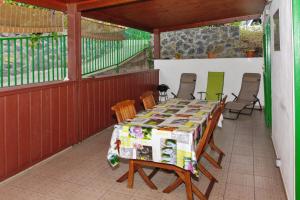 een tafel en stoelen op de achterveranda van een huis bij Maison de 2 chambres avec terrasse amenagee et wifi a Saint Leu a 1 km de la plage in Saint-Leu