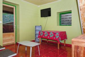 een kamer met een tafel en een tv aan de muur bij Maison de 2 chambres avec terrasse amenagee et wifi a Saint Leu a 1 km de la plage in Saint-Leu