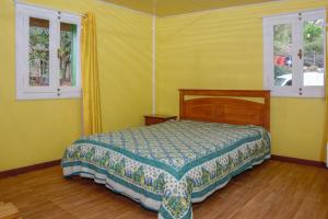 een slaapkamer met een bed en 2 ramen bij Maison de 2 chambres avec terrasse amenagee et wifi a Saint Leu a 1 km de la plage in Saint-Leu