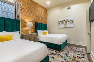 a bedroom with two beds and a brick wall at The Pontchartrain in New Orleans