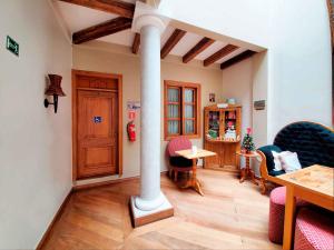 ein Wohnzimmer mit einer Säule, einem Tisch und Stühlen in der Unterkunft Casa Joaquin Boutique Hotel in Quito