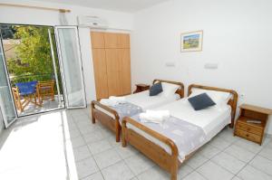 a bedroom with two beds and a balcony at Alexis Studios and Apartments in Agia Effimia