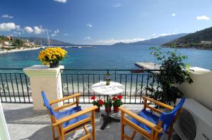 a balcony with two chairs and a table with a view of the water at Alexis Studios and Apartments in Agia Effimia