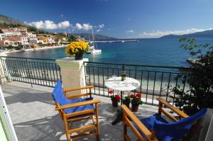 balcón con mesa, sillas y vistas al océano en Alexis Studios and Apartments en Agia Efimia
